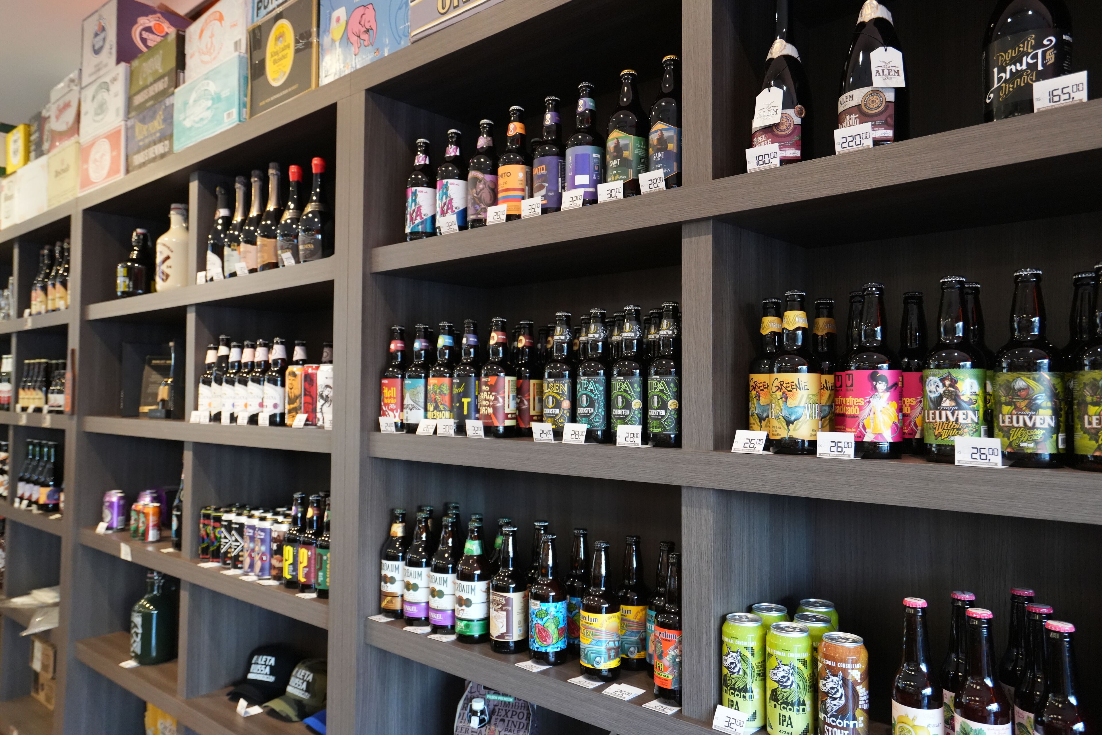 Shelves stocked with various bottles and cans of beverages, likely in a store or bar setting.