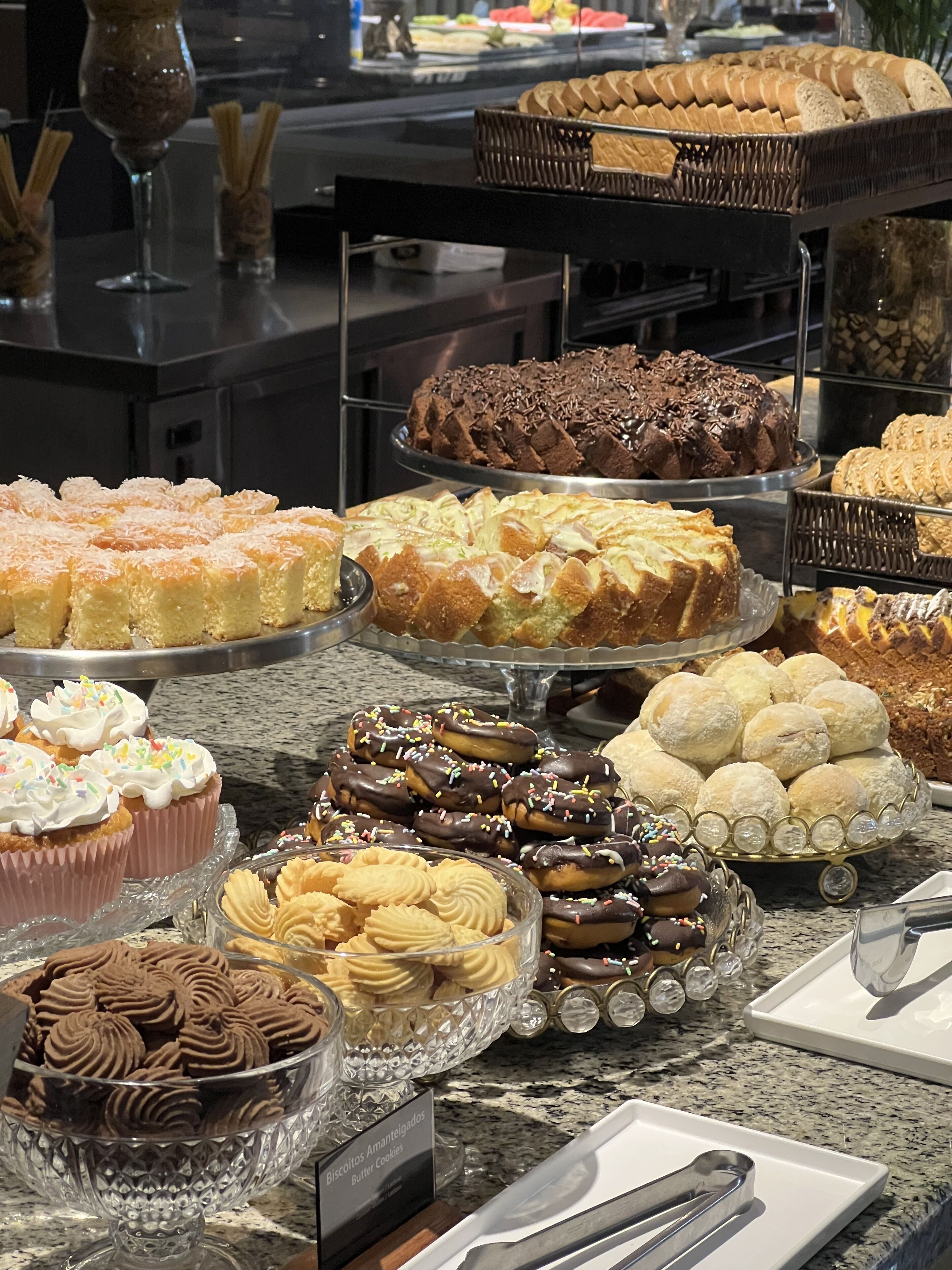 Un bufé con diversos postres, entre ellos pasteles, galletas y productos de pastelería.