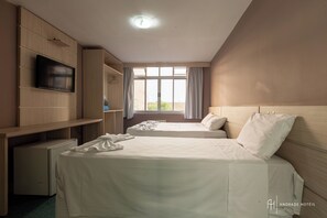 A hotel room with two beds, a TV, a desk, and a window with curtains. - Rede Andrade San Martin (Curitiba)