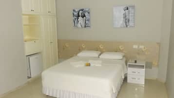 A bedroom with a bed, a nightstand, a dresser, and two wall art pieces.