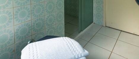 Une salle de bain avec des carreaux décorés, des toilettes avec une serviette à disposition, un sèche-mains et une porte.