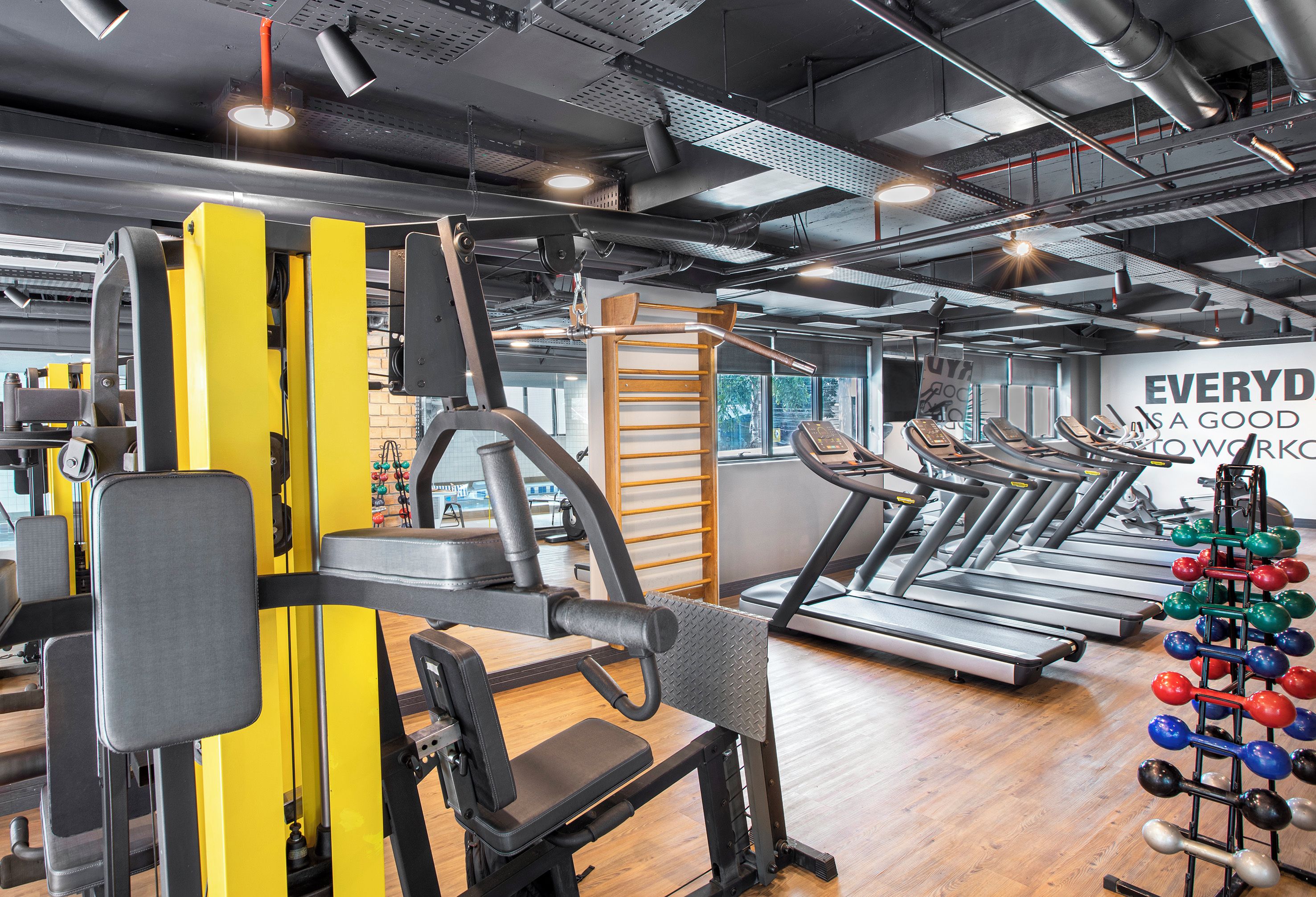 A gym with exercise equipment, treadmills, and a motivational wall.