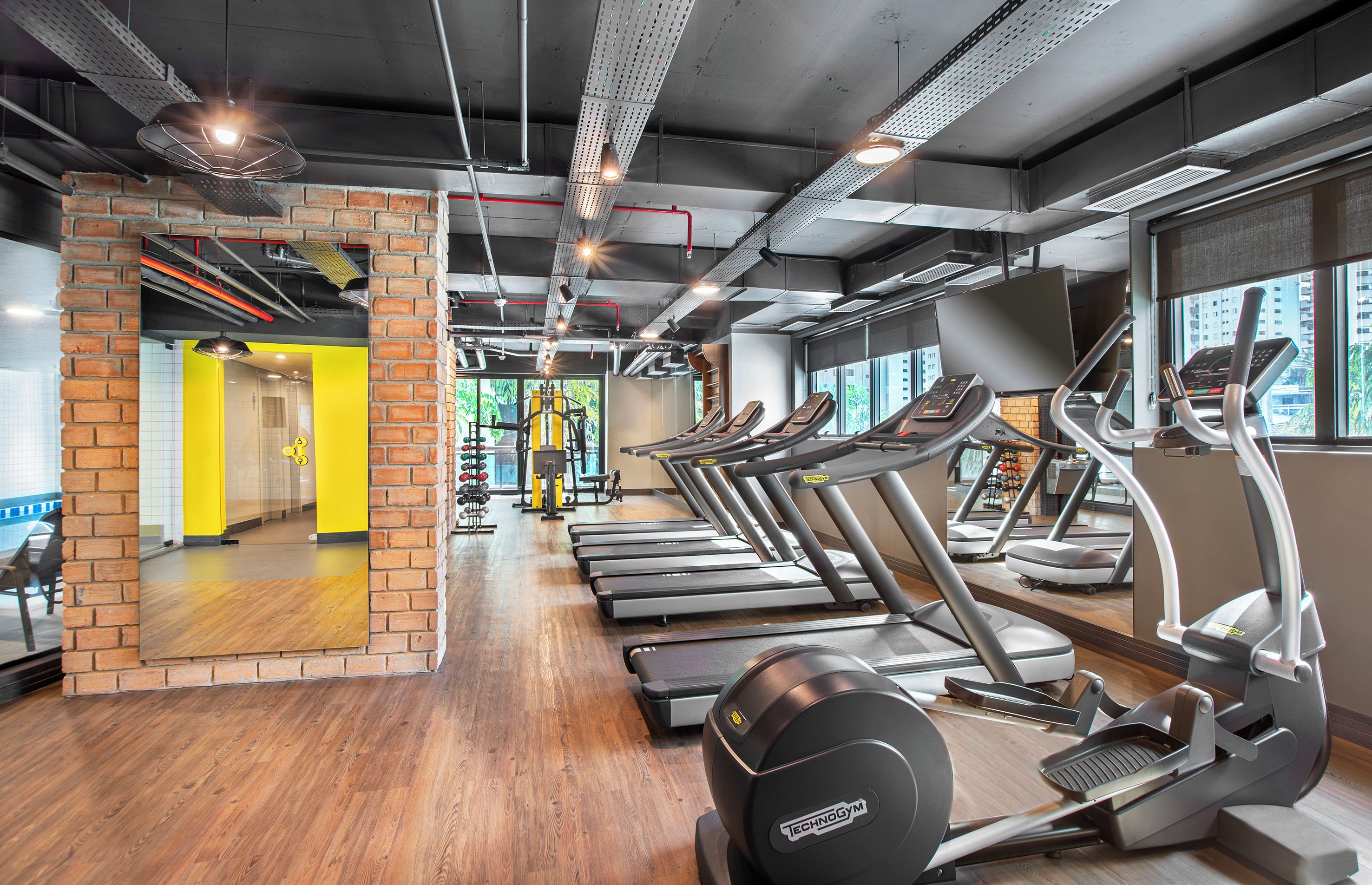 A gym with treadmills, elliptical machines, and weight equipment.