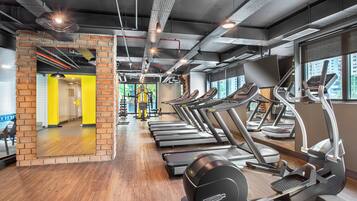 A gym with treadmills, elliptical machines, and weight equipment.
