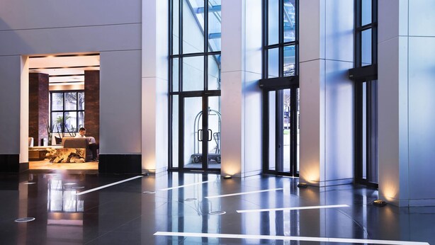 Un vestíbulo moderno con ventanas amplias, un mostrador de recepción y una zona de estar.