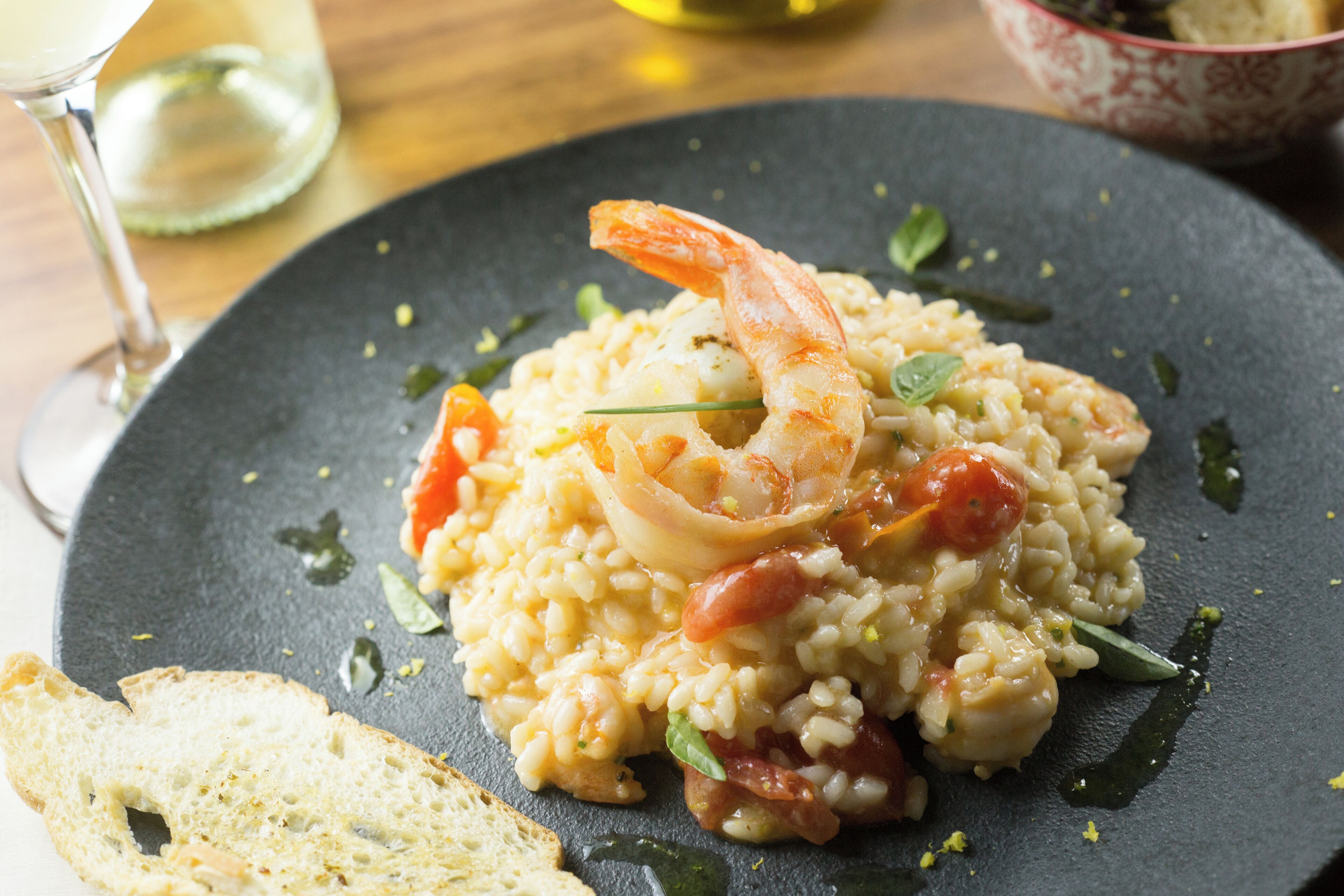 A plate of risotto with shrimp and vegetables.