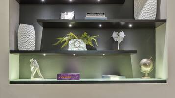 A modern interior with three shelves displaying decorative items and a large wooden sculpture.