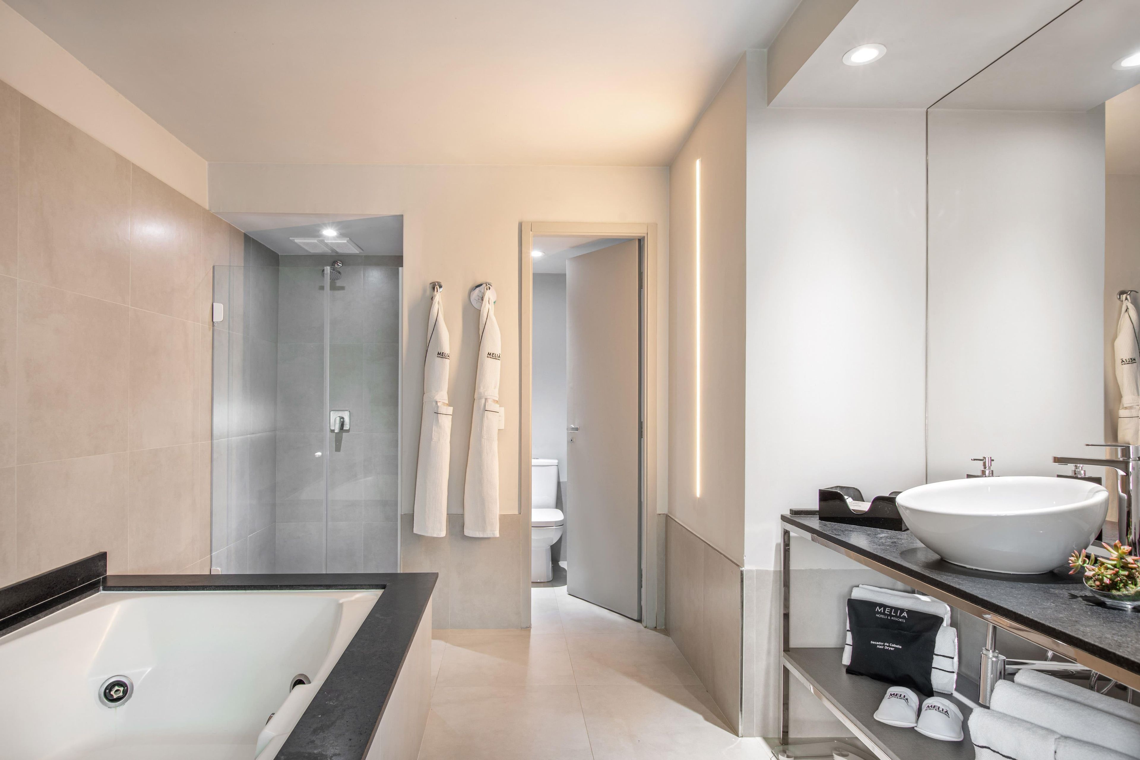 Un baño moderno con bañera, un lavamanos grande y una ducha a pie.