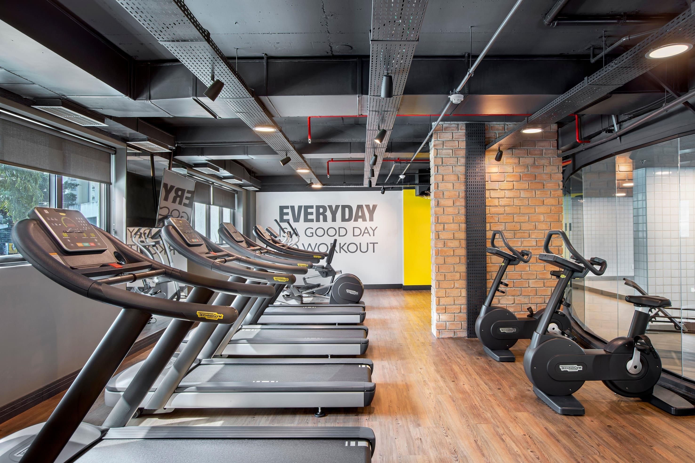 A gym with treadmills, stationary bikes, and a motivational wall.