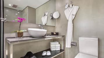 Un baño moderno con un lavamanos blanco grande, un espejo, un perchero y un inodoro.