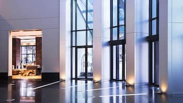 Una hall moderna con ampie vetrate, una reception e un'area salotto.