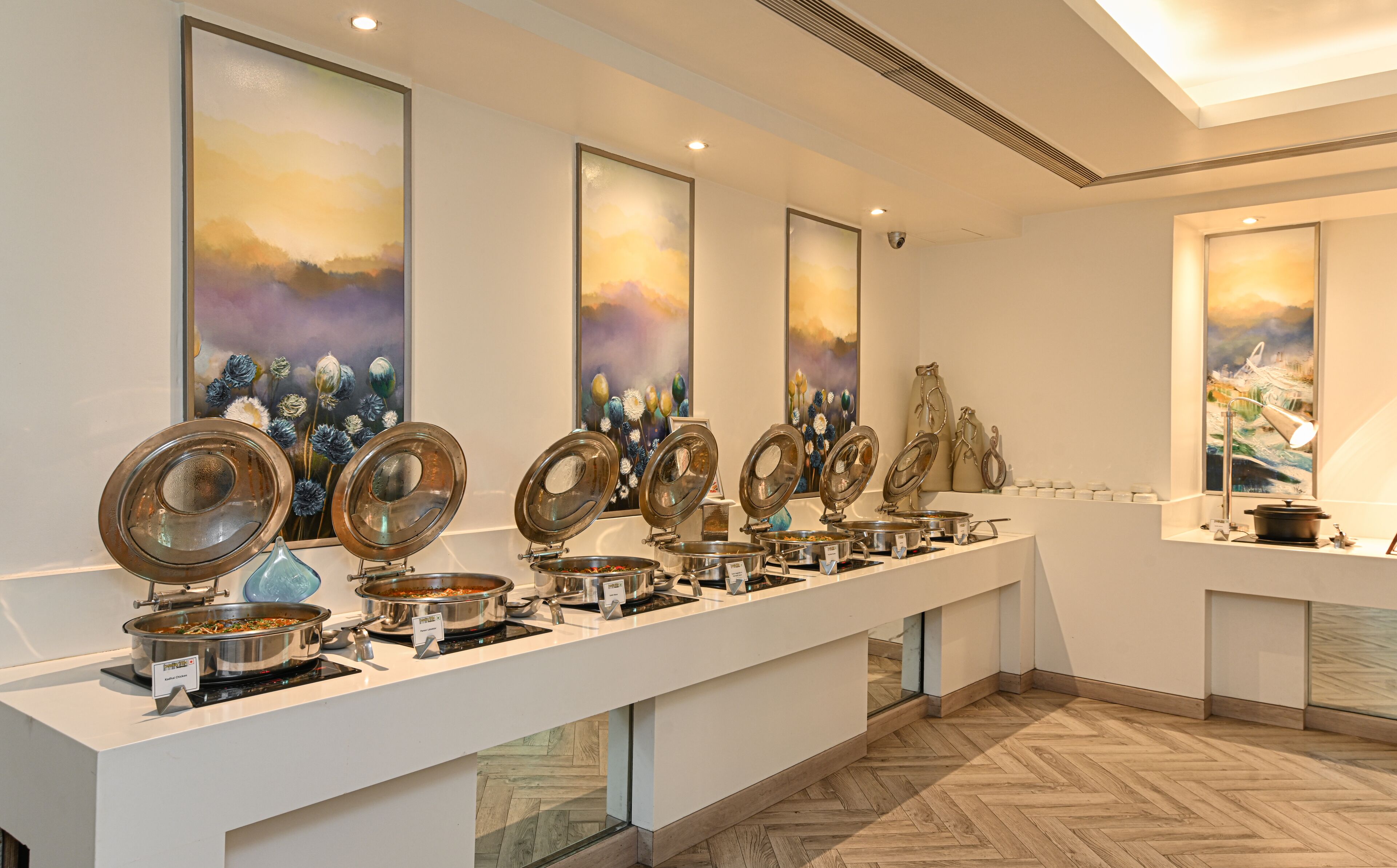 Un buffet avec plusieurs points de service, chacun proposant une variété de plats et un panneau indiquant le type de nourriture.