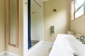 Suite Confort, no fumadores, vistas parciales al mar | Baño | Ducha, secador de pelo y toallas