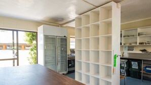 A kitchen with white cabinets, a wooden table, and a glass-fronted refrigerator.