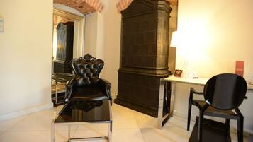 A room with a black leather chair, a desk, and a fireplace.