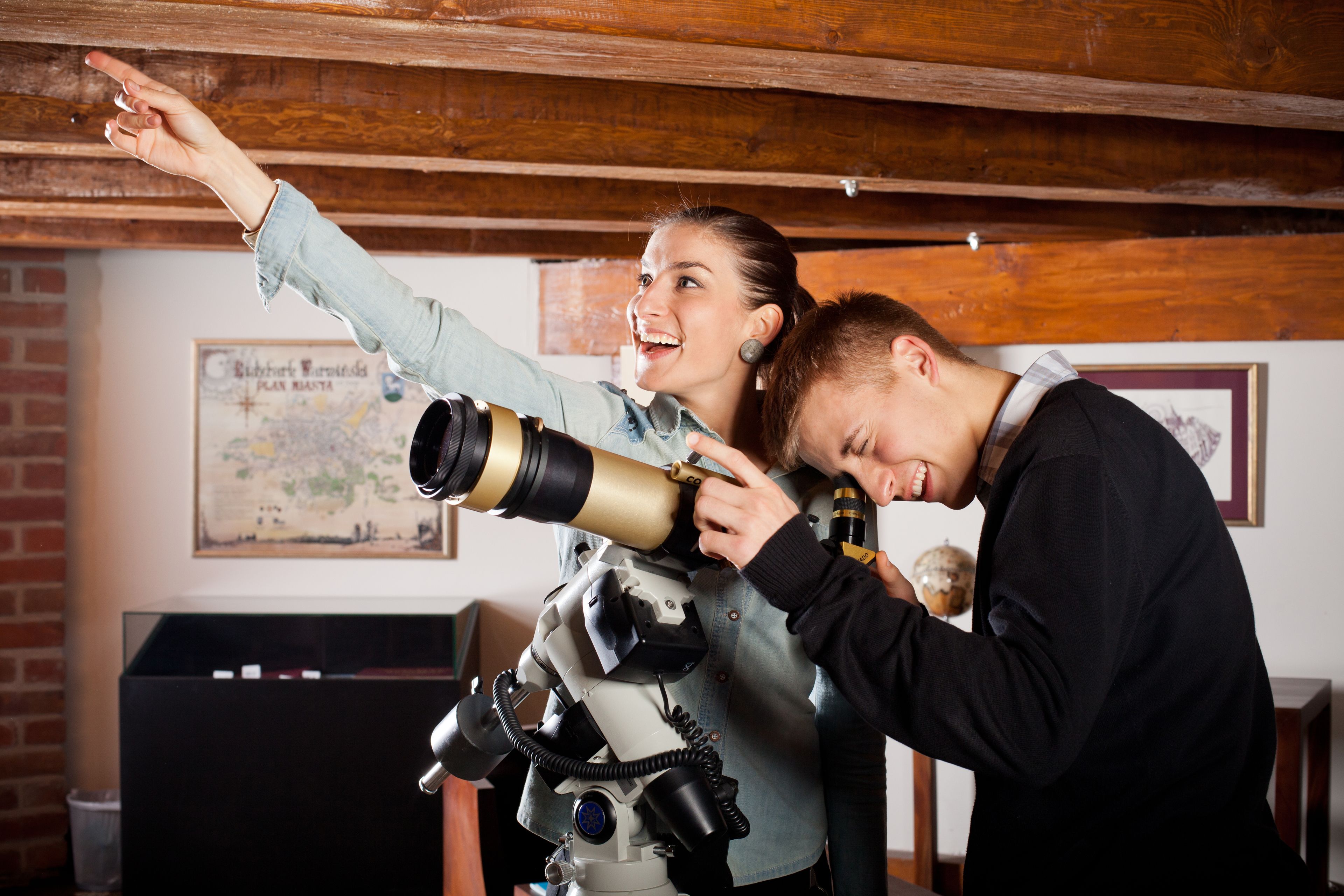 A person adjusting a telescope.