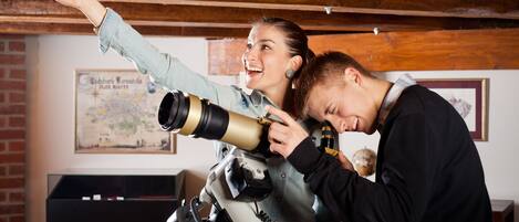 A person adjusting a telescope.