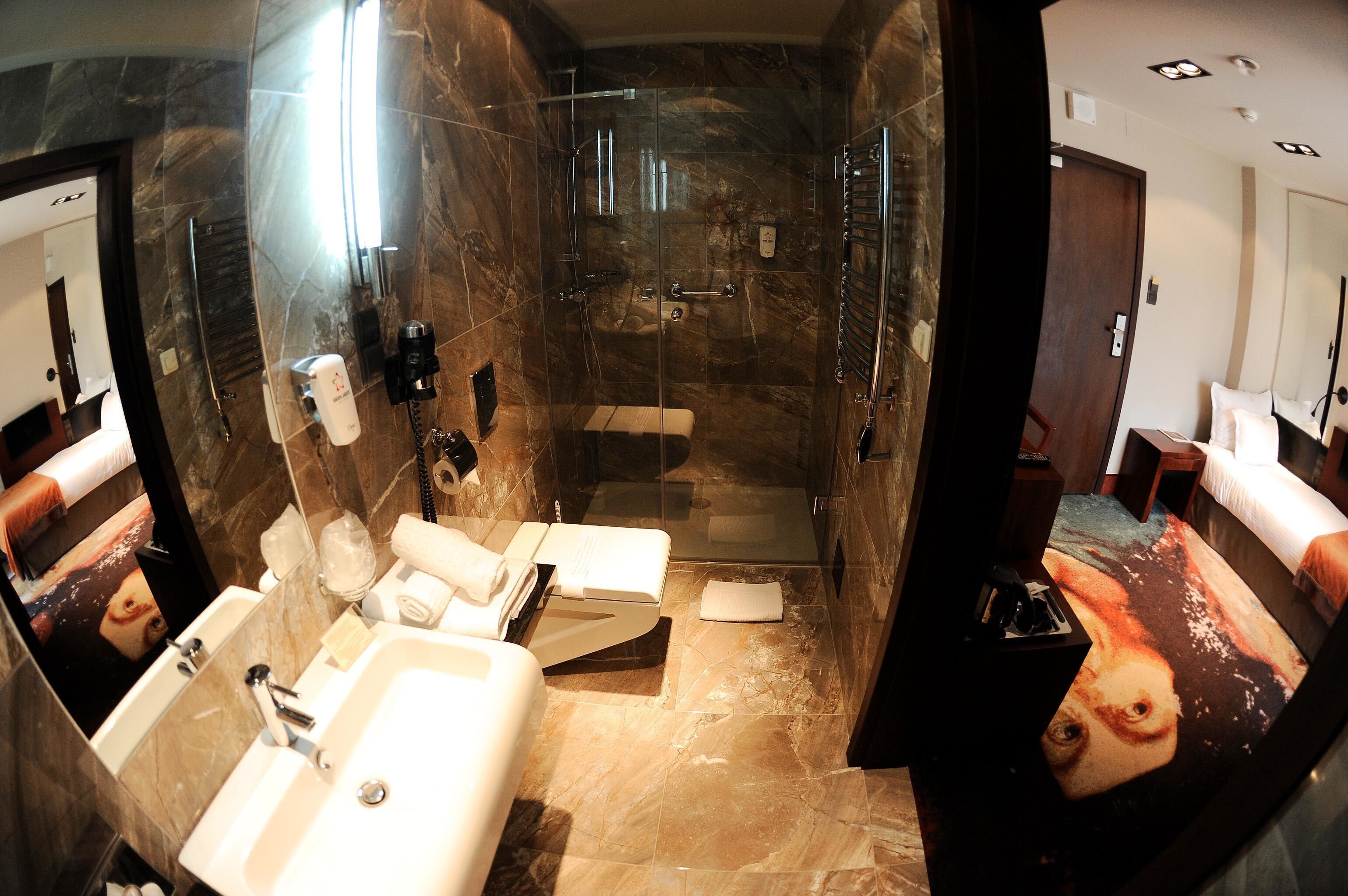 A modern bathroom with a glass-enclosed shower, a sink, and a mirror.