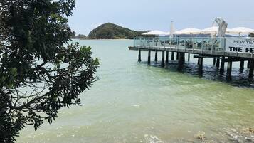 A pier extending into calm waters with a restaurant on the right side.