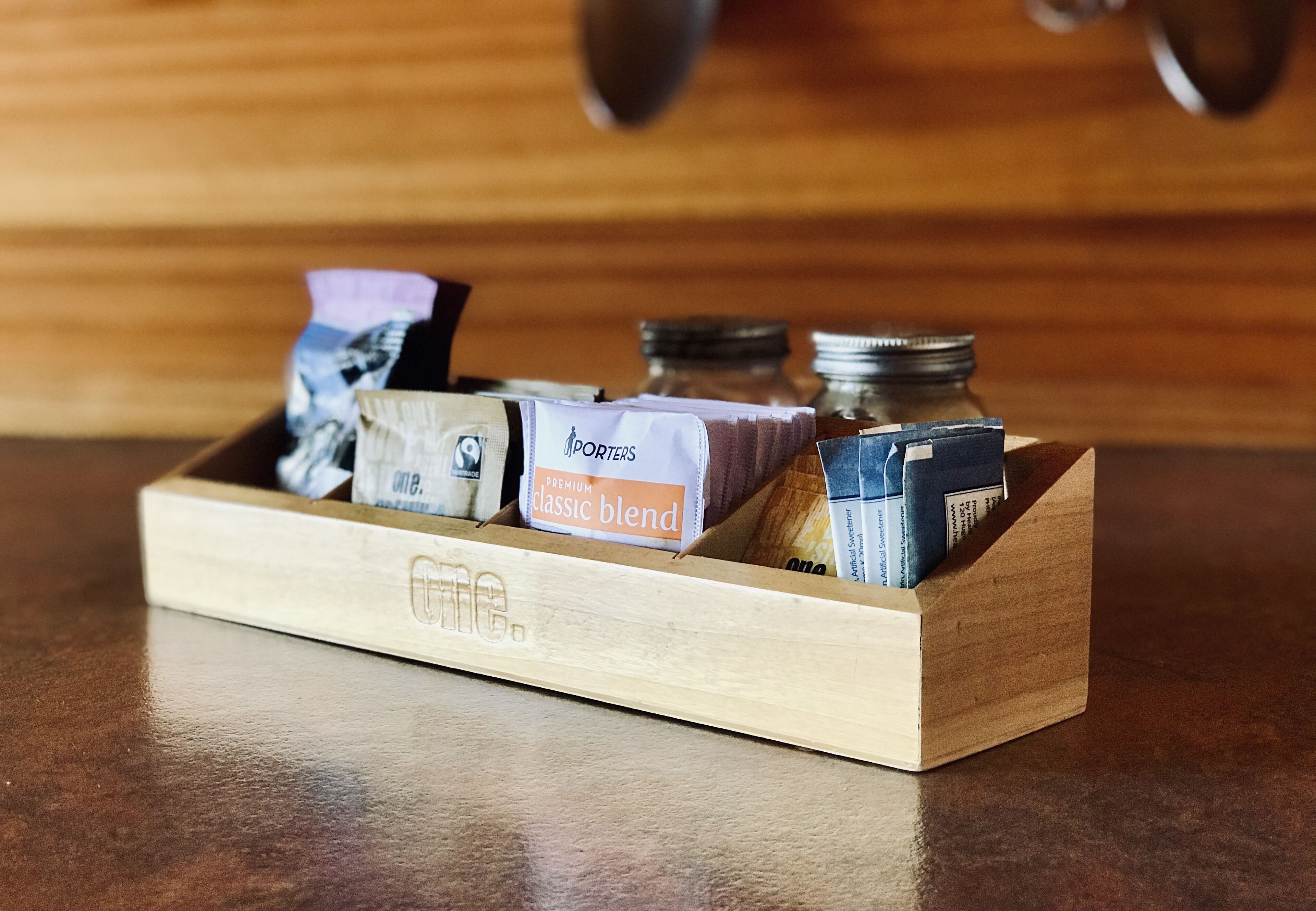 A wooden box containing various items, including a box labeled "Porters Premium Classic Blend" and other small containers.