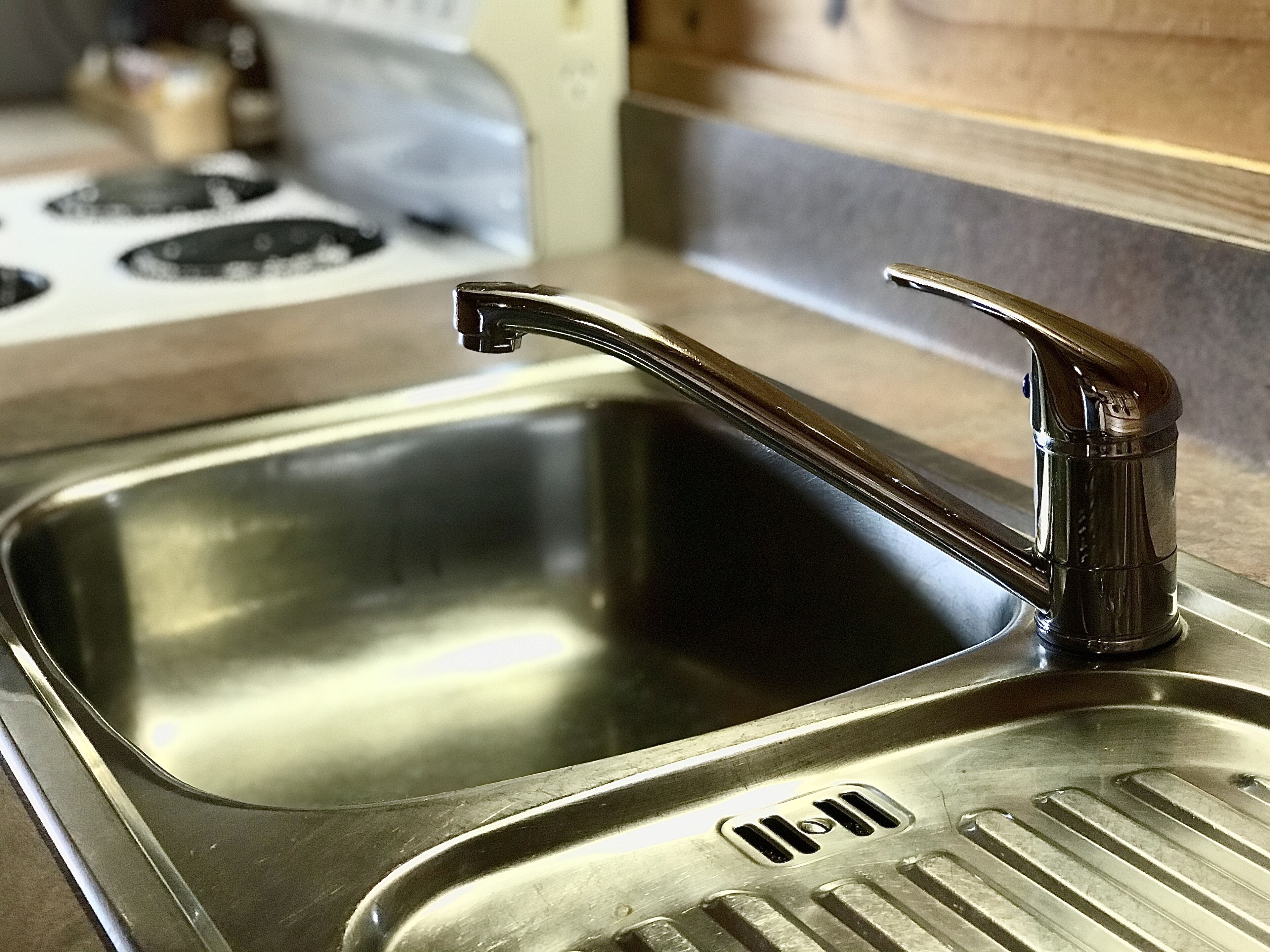 A stainless steel kitchen sink with a modern faucet.