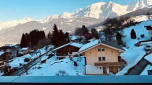 A snow-covered mountain village with wooden houses and a clear view of snow-capped peaks in the background. - Le Floralp (Combloux)