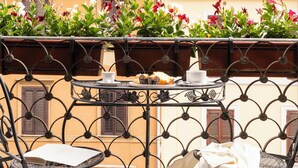 A balcony with a table, chairs, and a hanging towel. - The Roman Empire Guesthouse (Rome)