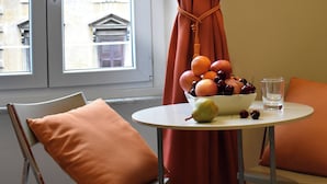 A room with a table set for breakfast, featuring a bowl of fruit and a glass of water. - The Roman Empire Guesthouse (Rome)