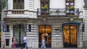 A building with ornate iron gates and a balcony with plants. - Algodon Mansion (Buenos Aires)