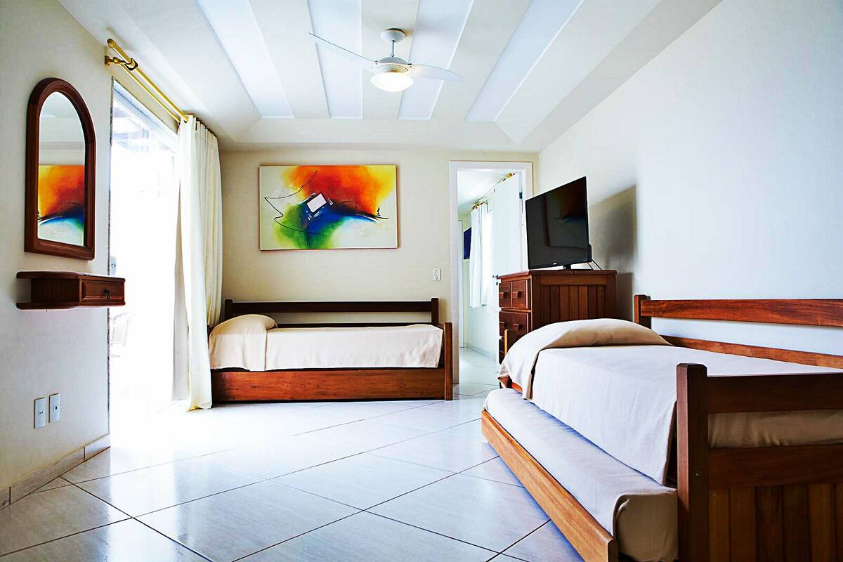 Ein Hotelzimmer mit einem großen Bett, einem Fernseher und einem Deckenventilator.