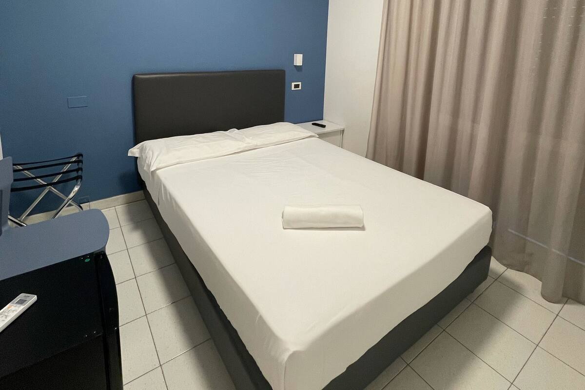 Ein Hotelzimmer mit einem Bett, einem Schreibtisch und einem Stuhl.