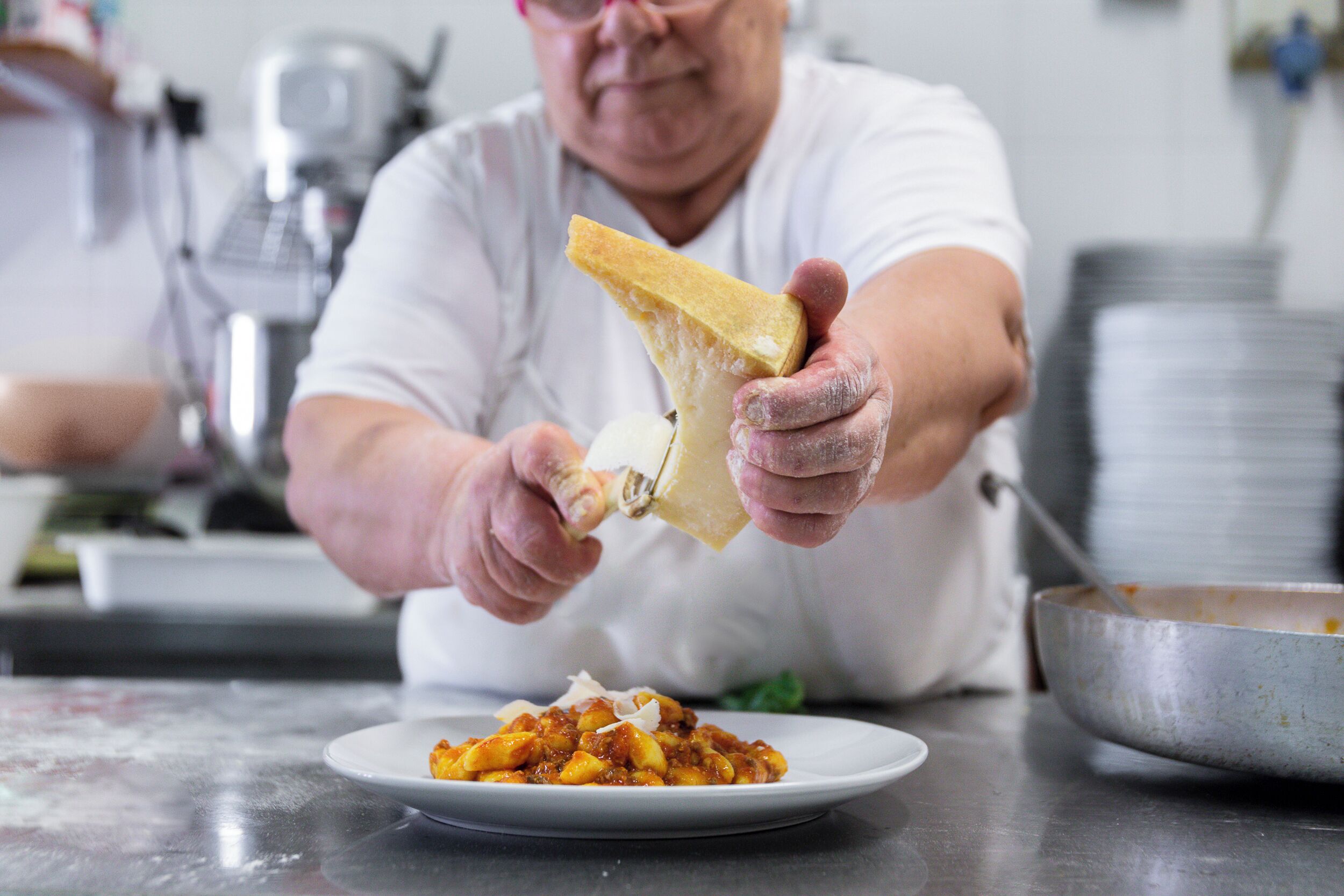 Une personne qui sert de la nourriture d’une assiette dans un bol.