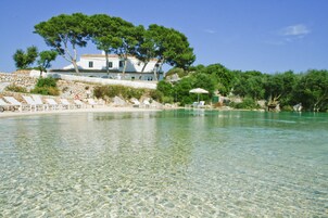 Una piscina al aire libre, sombrillas, sillones reclinables de piscina