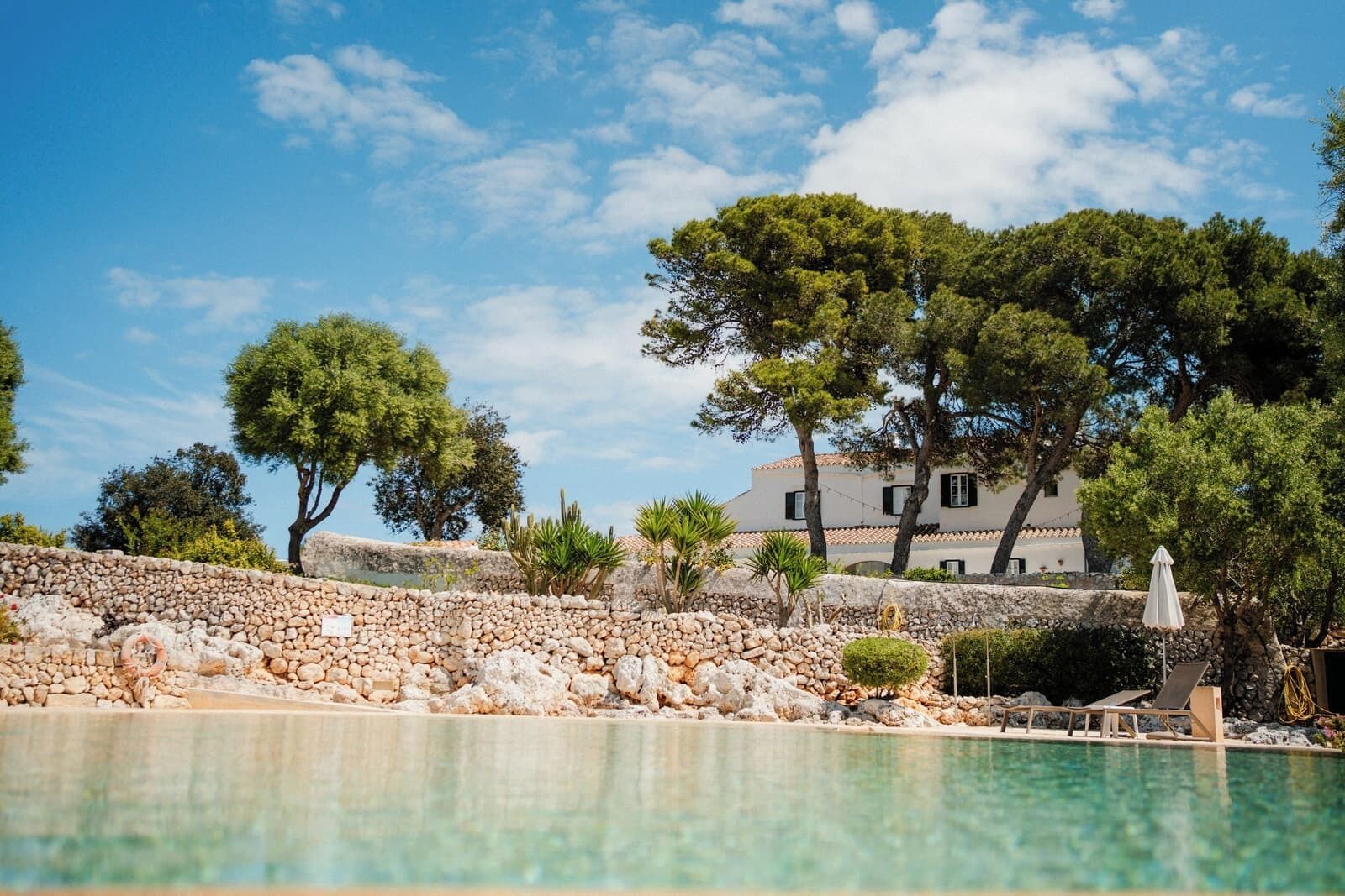 Una piscina al aire libre, sombrillas, tumbonas
