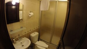Un baño con lavamanos, inodoro y ducha.
