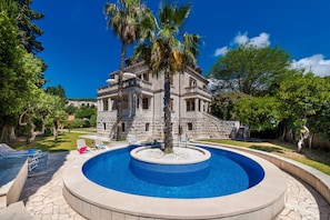 A stone building with a pool, surrounded by trees and a clear sky. - Boutique Villa Filaus (Dubrovnik)