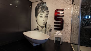 Un baño moderno con una bañera independiente, un lavamanos empotrado y una cabina de ducha con paredes de cristal.
