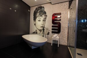 A modern bathroom with a freestanding bathtub, a wall-mounted sink, and a glass shower enclosure.