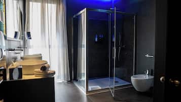 Un baño moderno con ducha de vidrio, un lavamanos grande y un bidé.