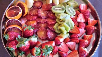 Una bandeja de frutas con fresas, kiwi, naranjas sanguinas y plátanos.