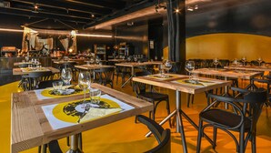 A restaurant with multiple tables, each set with wine glasses and menus. - Aiden by Best Western JHD Dunant Hotel (Castiglione delle Stiviere)