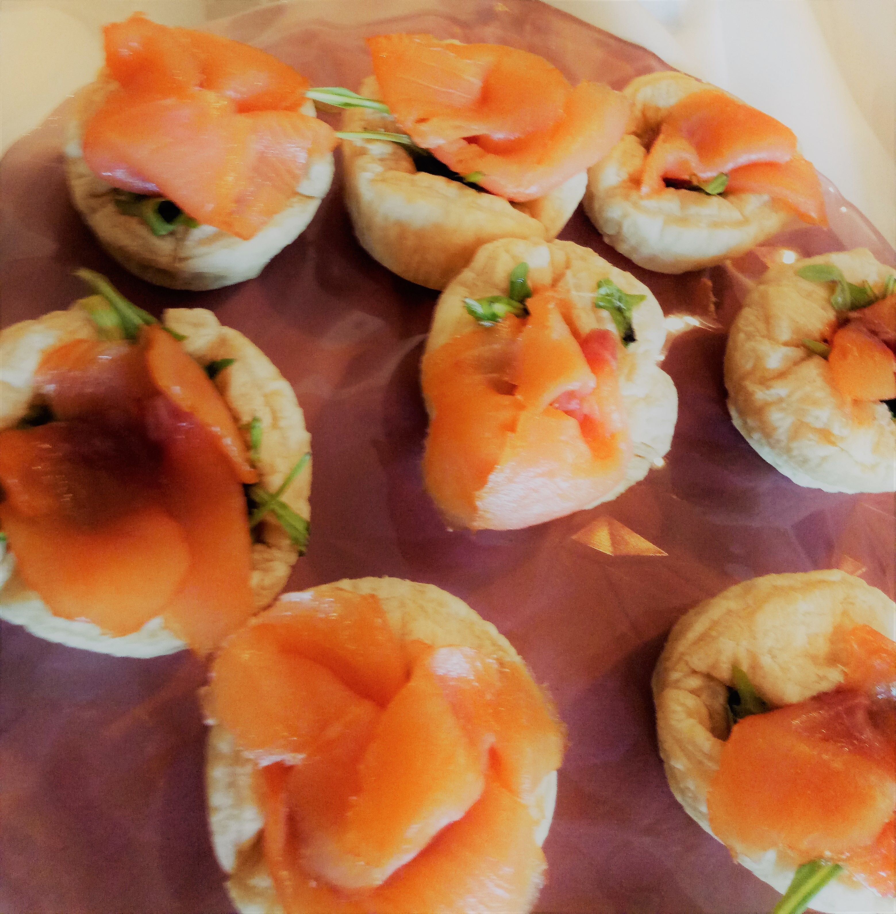 Una bandeja de aperitivos con salmón ahumado y hierbas.