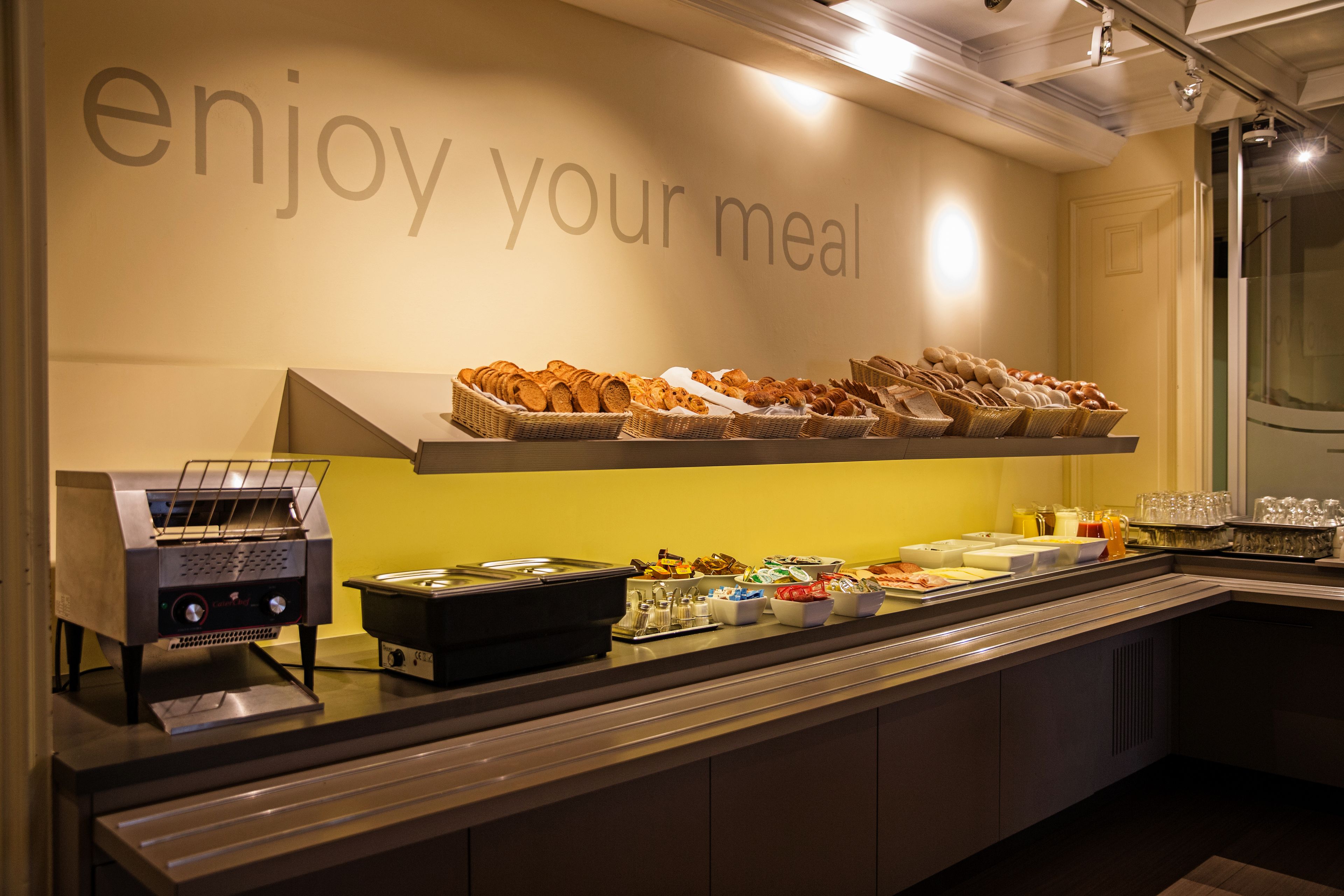 A buffet setup with various food items and a coffee machine.
