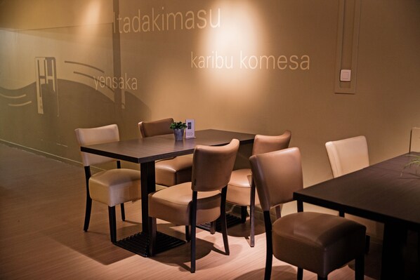 A conference room with a dark table and beige chairs, a potted plant, and a projection screen with Japanese text. - Antwerp Harbour Hotel (Antwerp)