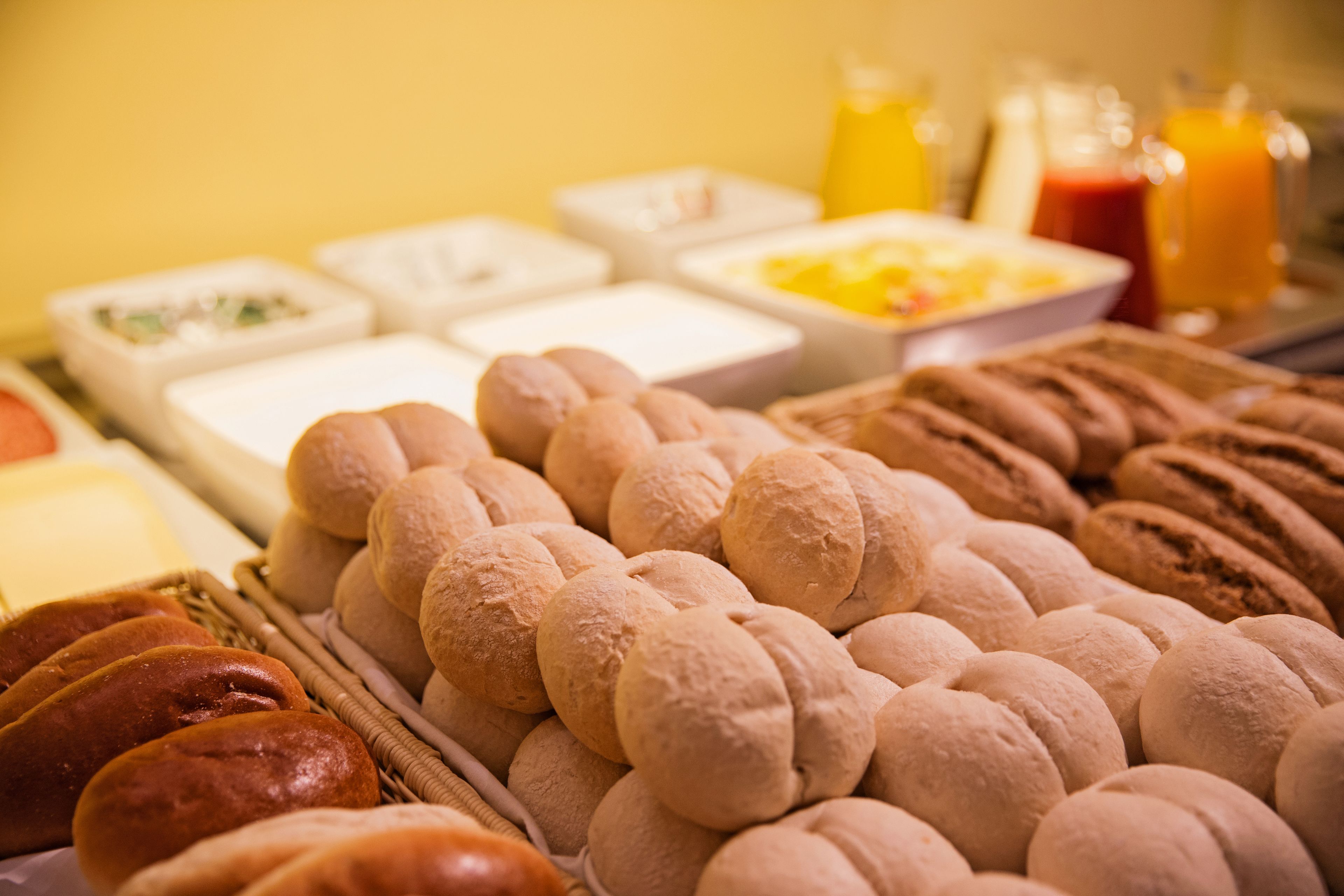 Een ontbijtbuffet met verschillende soorten brood en gebak.