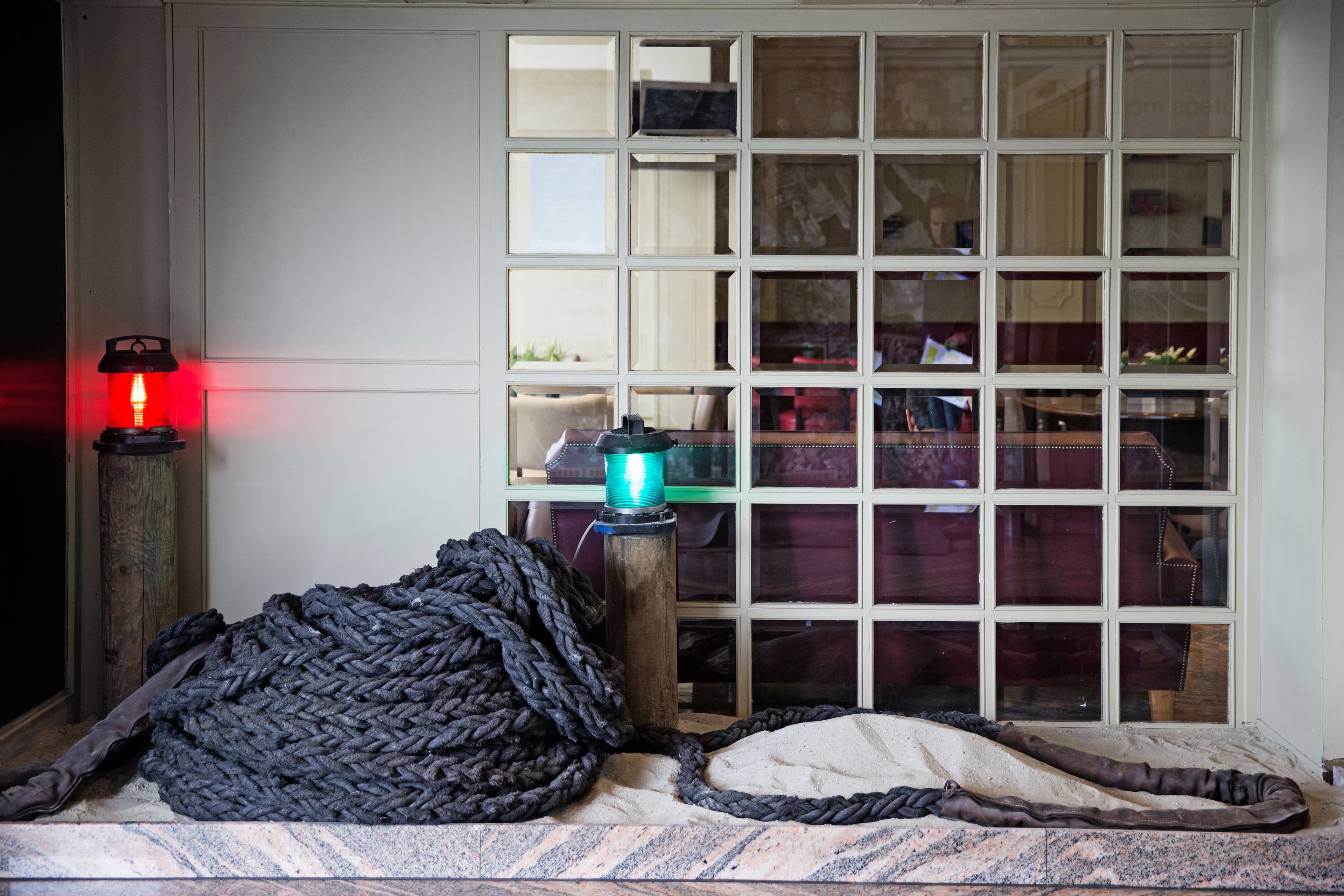 Een kamer met een groot raam, een rode lantaarn en een groene lamp.