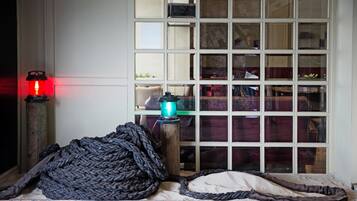 A room with a large window, a red lantern, and a green lamp.