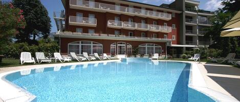 Una piscina al aire libre de temporada, sombrillas