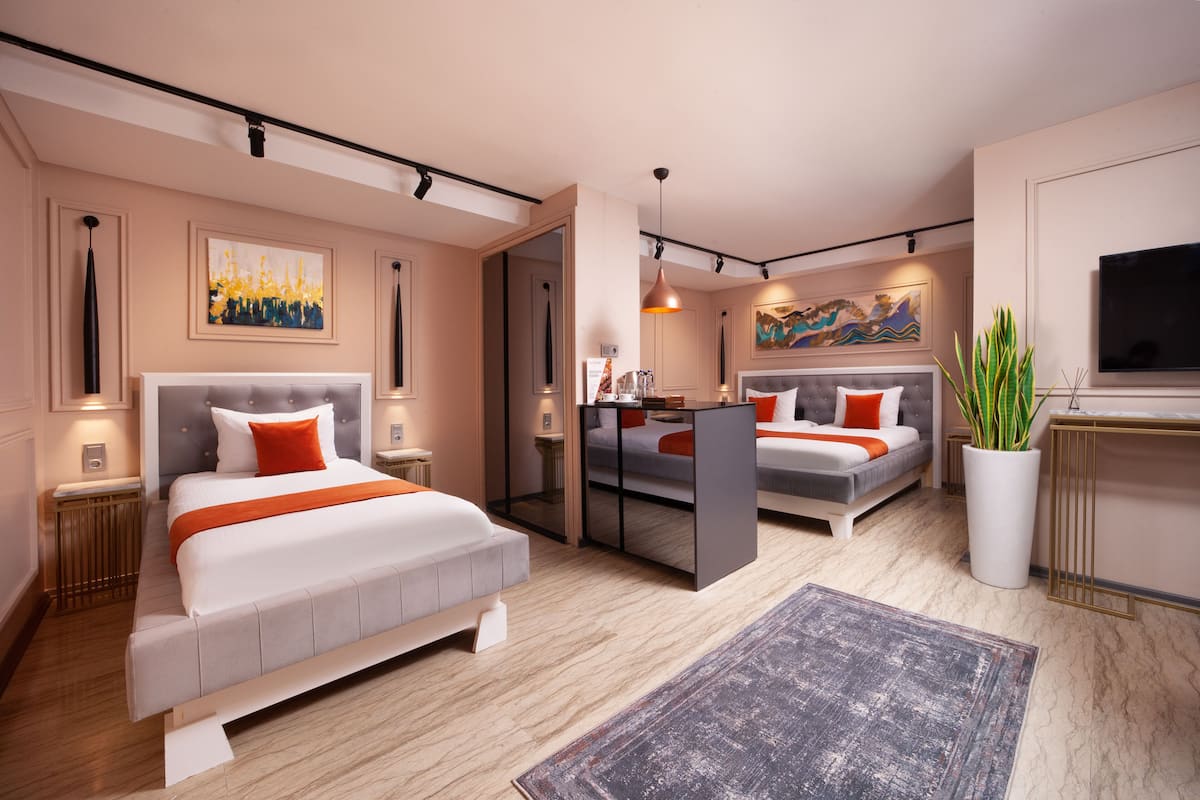 A modern hotel room with a large bed, a desk, and a TV.