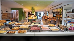 Een buffetgedeelte met diverse gerechten en een zithoek op de achtergrond.